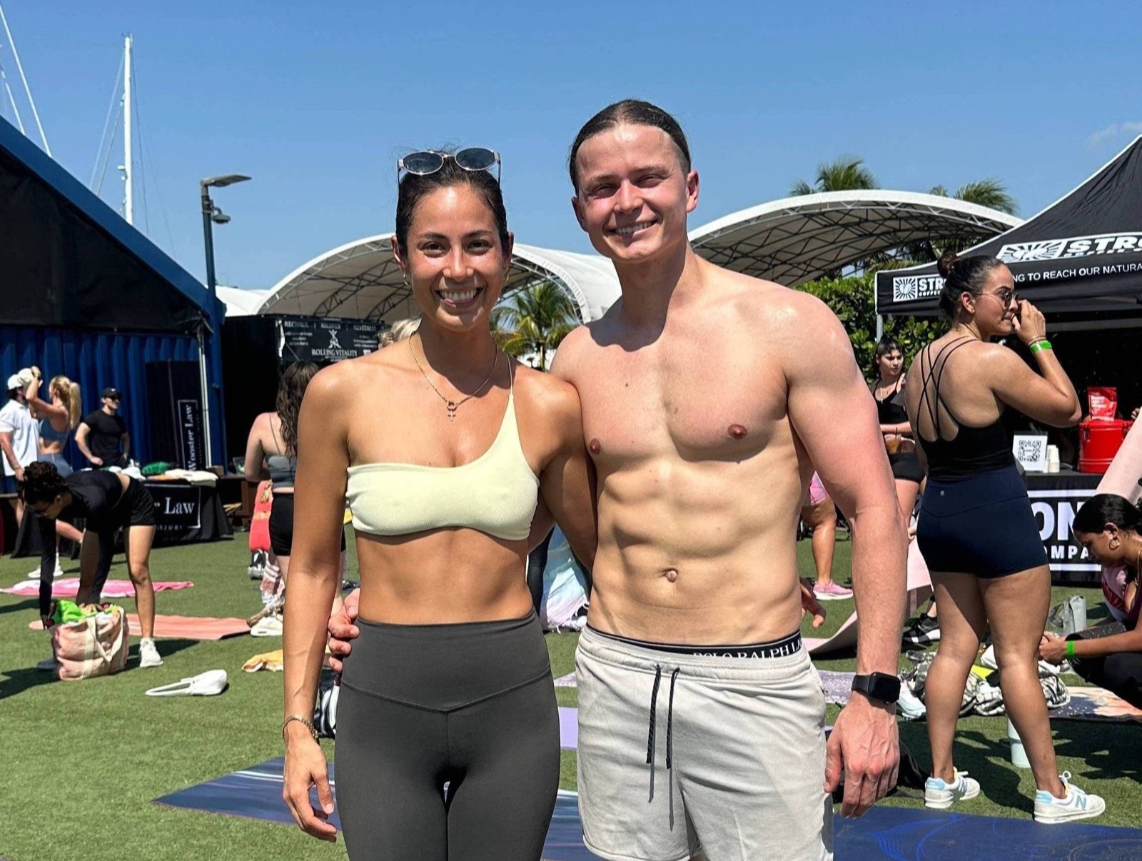 Aeran Thomas and Alexandra Terzi, smiling side by side at an outdoor fitness event in the sun
