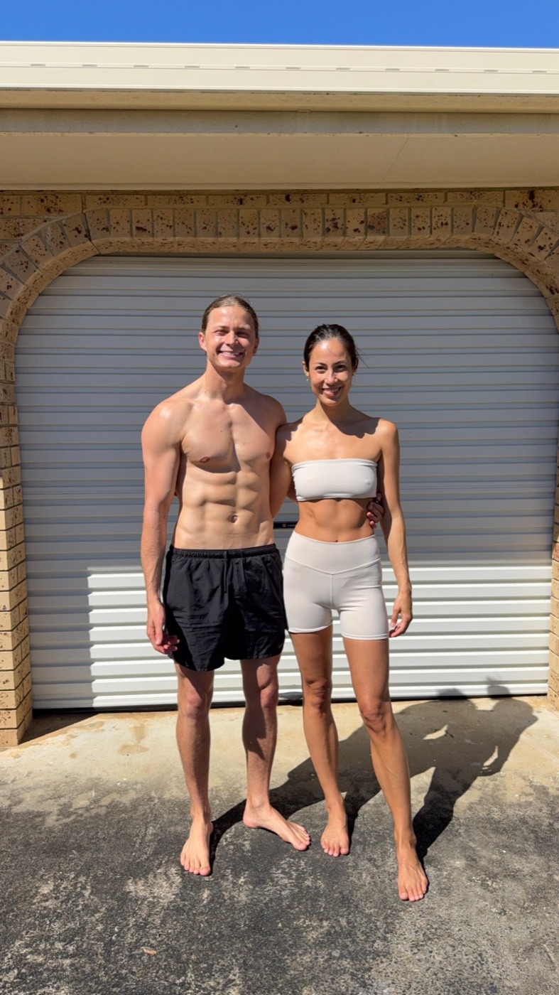 After: Aeran and Alexandra smiling in front of the same garage door, leaner and more defined after 50 days